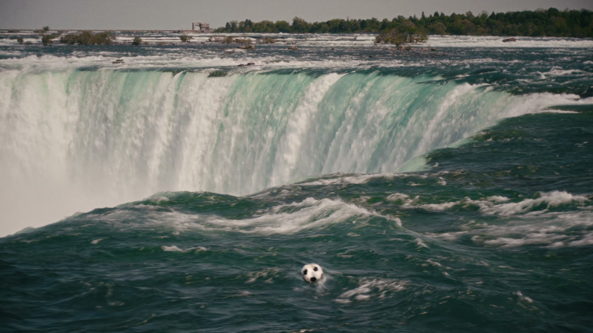 A soccer ball floating at the brink of Horseshoe Falls, the pivotal moment of the wordless campaign film
