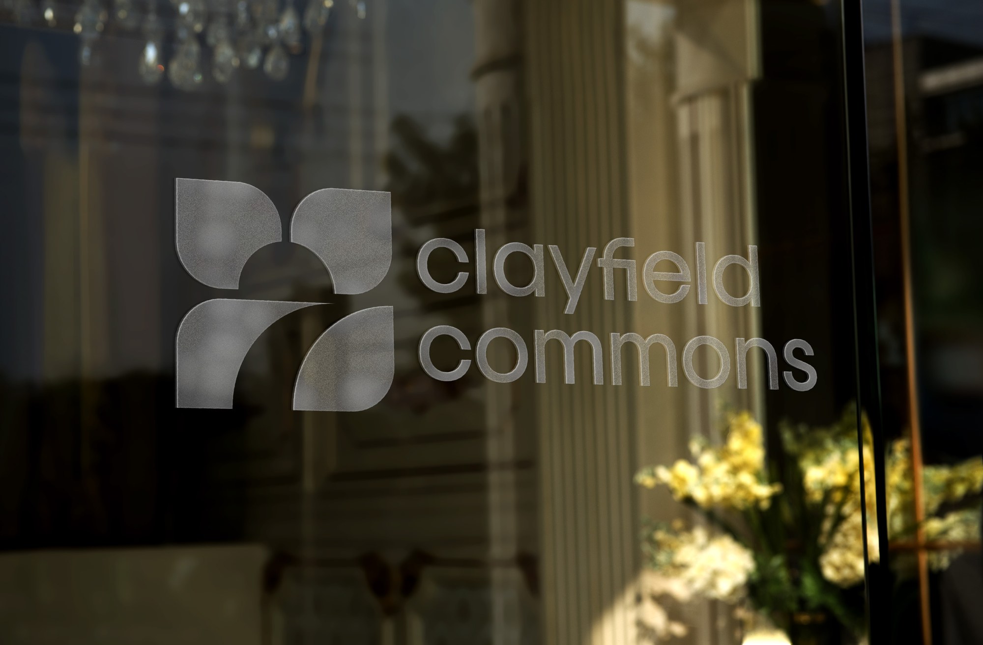 Clayfield Commons frosted logo decal on a storefront window