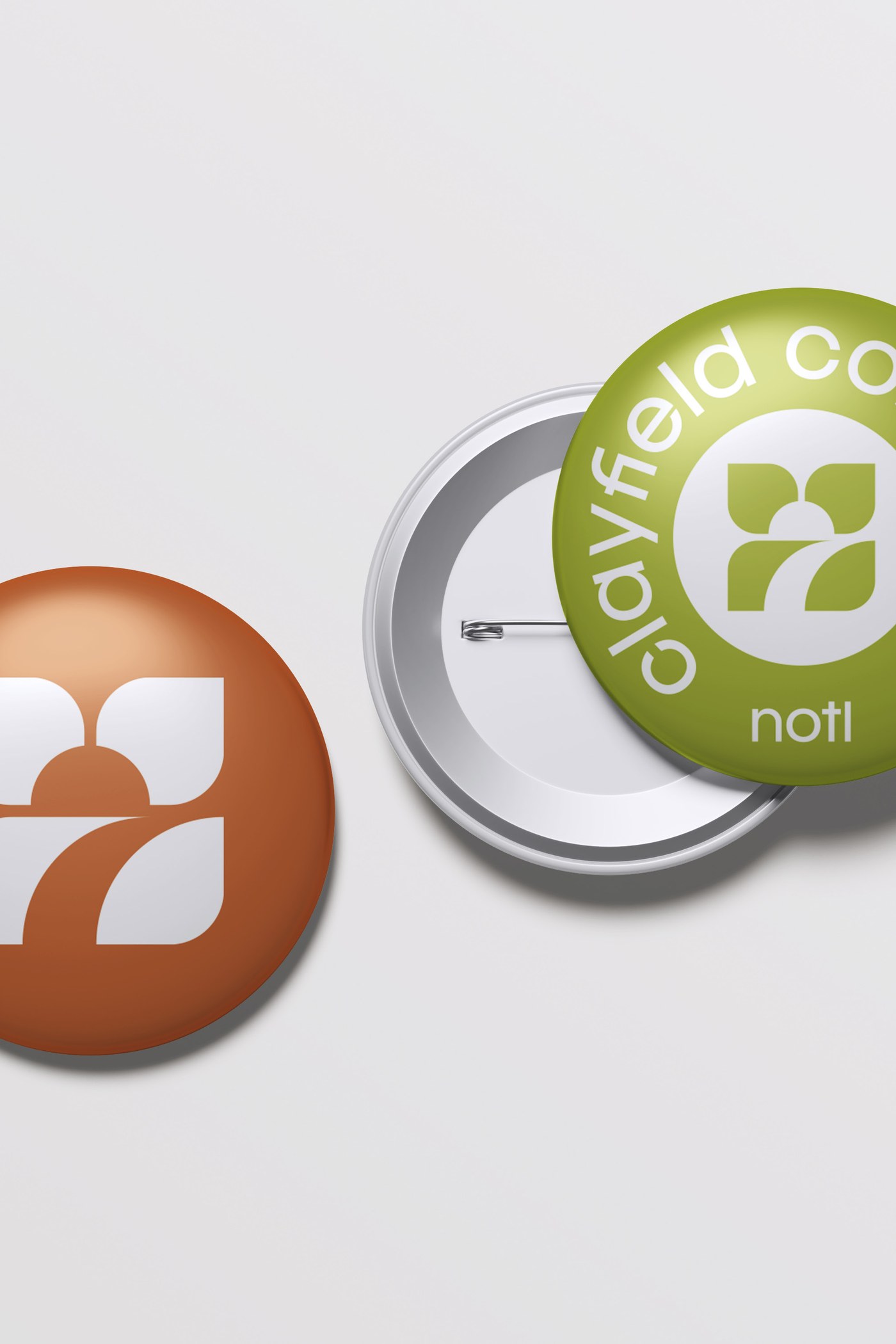 Clayfield Commons pin buttons in Clay and Field Olive with the Uptown NOTL badge