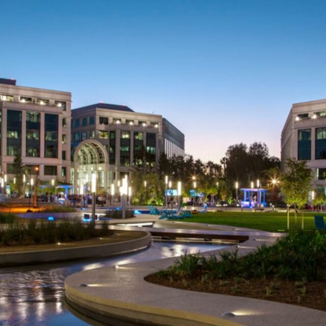 Evening view of Water Garden office buildings with illuminated fountains and landscaped plaza