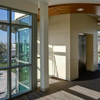 Interior hallway of the Lawndale Community Center with large glass windows and elevator access.