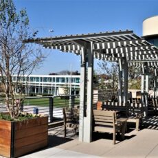 Outdoor terrace seating area at the Lawndale Community Center with pergola shade structures.