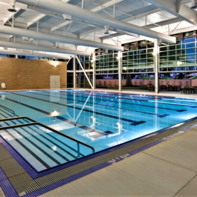 Indoor swimming pool at the Fullerton Community Center with lap lanes, wide steps, and large glass windows providing natural light