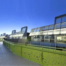 Modern school building with glass panels and green railing