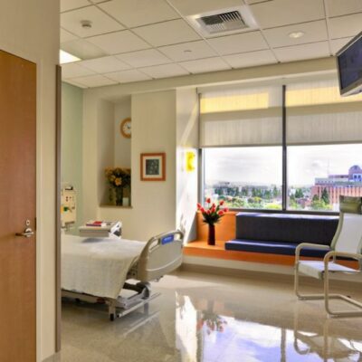 Hospital lobby with modern staircase, reception desk, and seating area