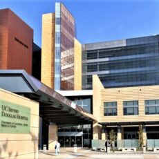 Modern hospital entrance with glass façade and multi-story tower