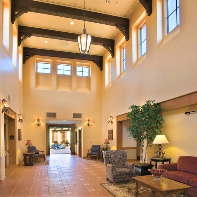 Lobby interior with high ceilings, exposed beams, and seating area