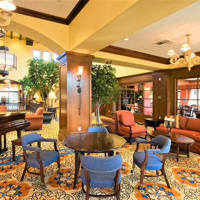 Community lounge with piano, seating areas, and decorative lighting