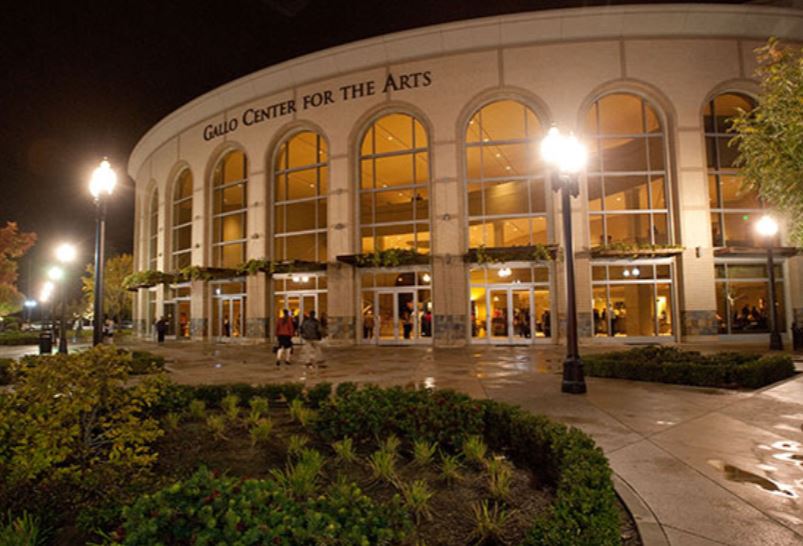 Renee and Henry Segerstrom Concert Hall exterior at night with curved glass façade illuminated against a deep blue sky.
