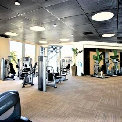 Spacious fitness center with exercise machines, large windows, and natural light.