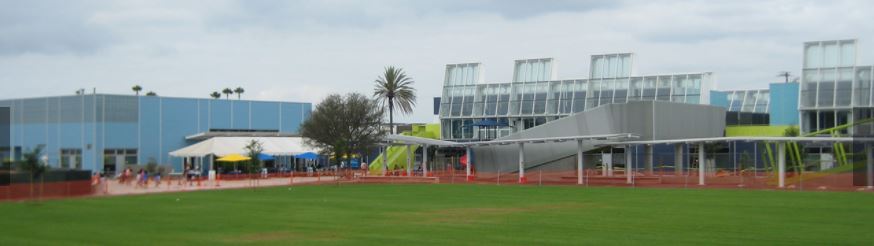 Exterior view of Edison Language Academy in Santa Monica, with blue and green modern buildings behind an open grass field.