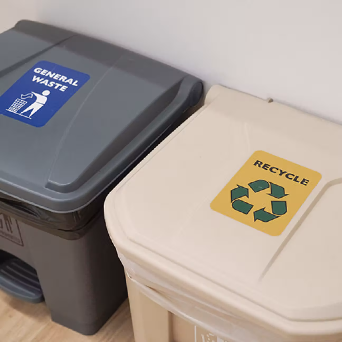 Two waste bins side by side, one gray labeled 'General Waste' and one beige labeled 'Recycle' with a recycling symbol.