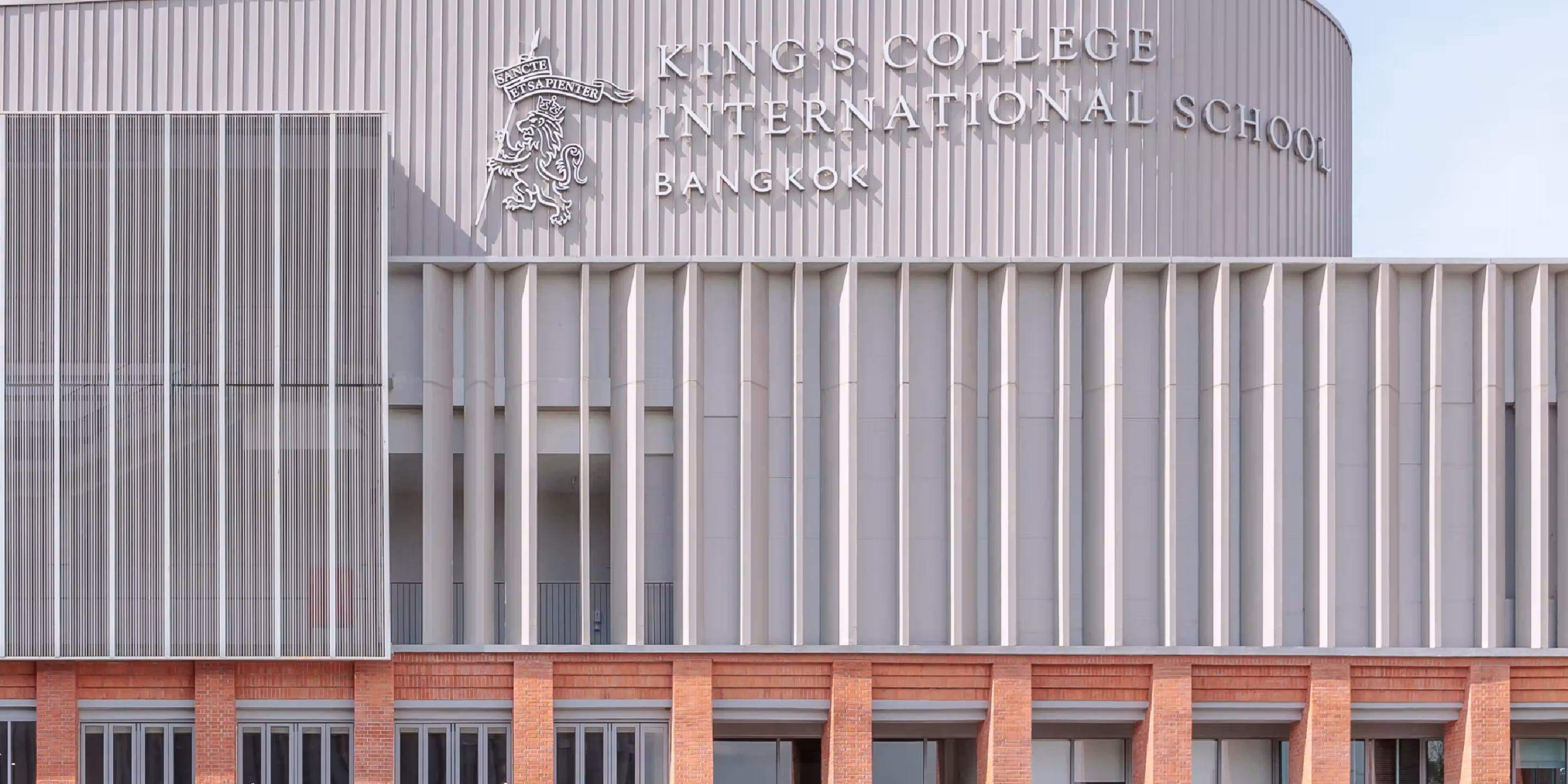 Modern King's College International School Bangkok building with vertical columns and brick lower facade.