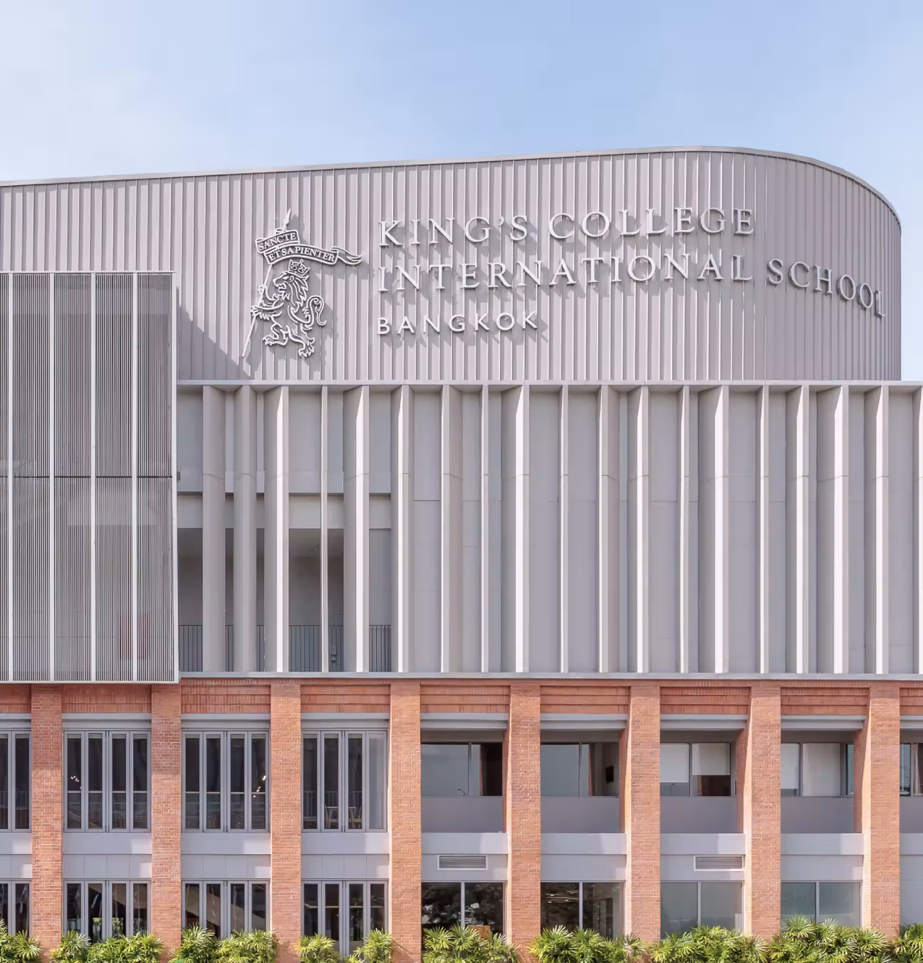 Modern building facade with King's College International School Bangkok sign and emblem on top.