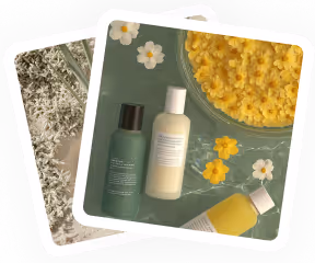 Two skincare bottles with yellow flower petals and a glass of yellow liquid on a green surface.