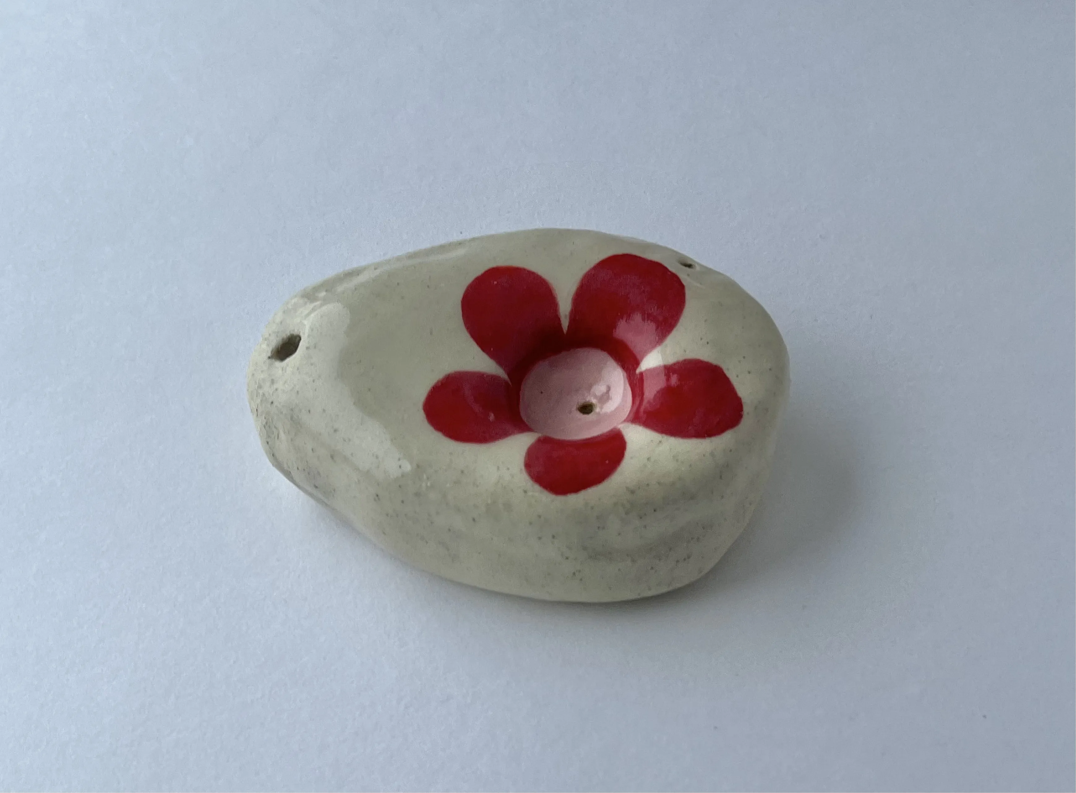 oval hand sized pipe with a red flower.