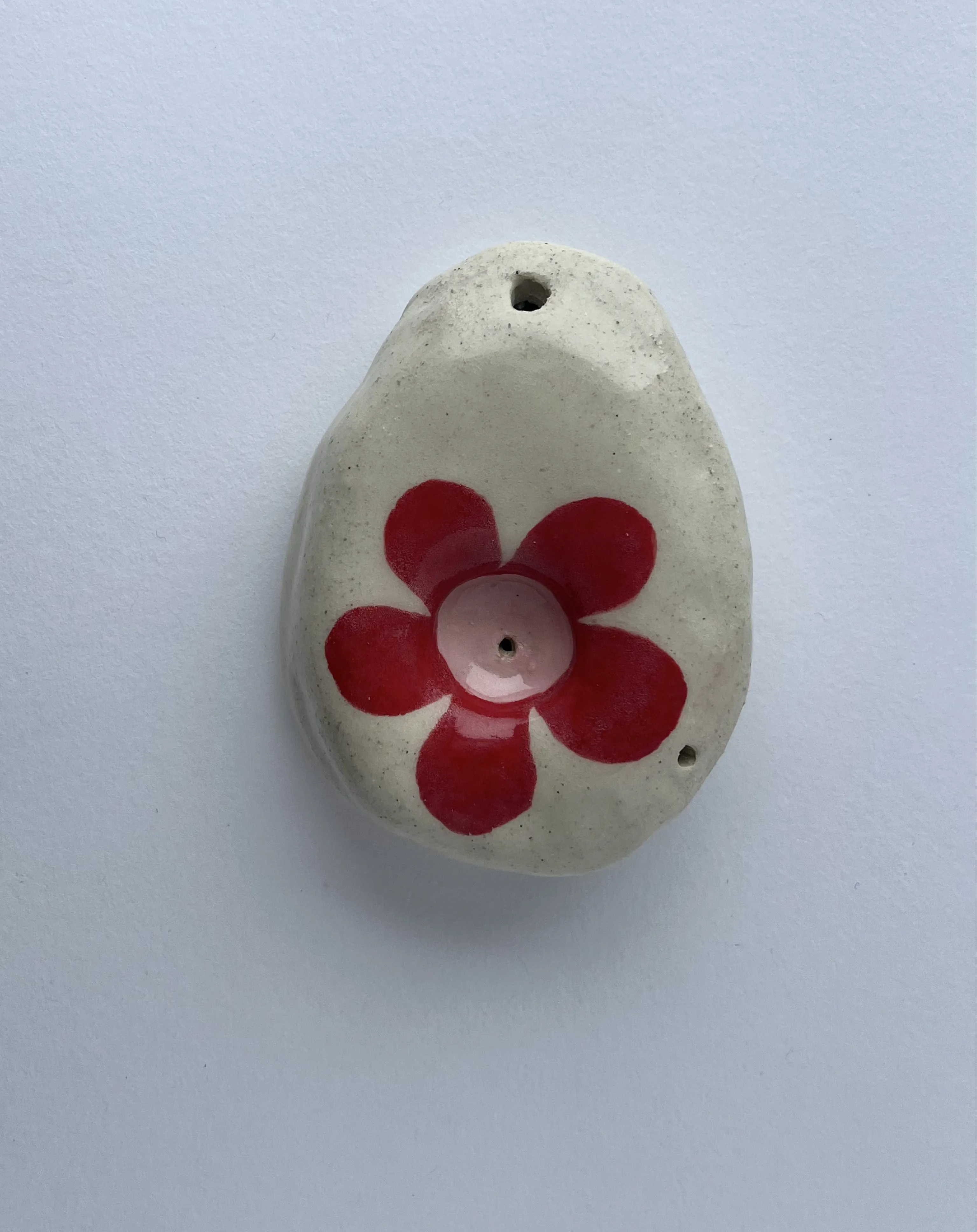 oval hand sized pipe with a red flower.