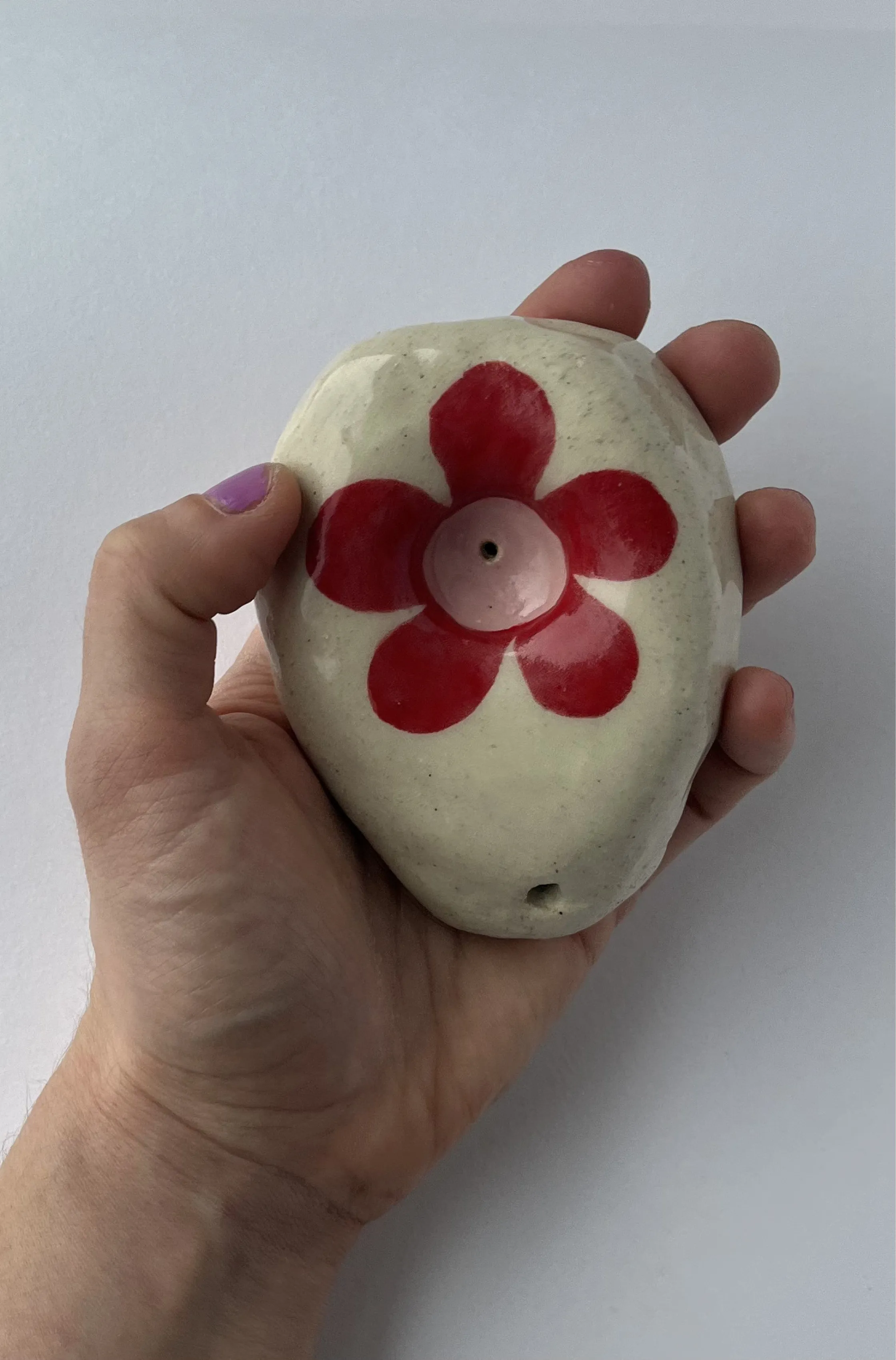 oval hand sized pipe with a red flower.
