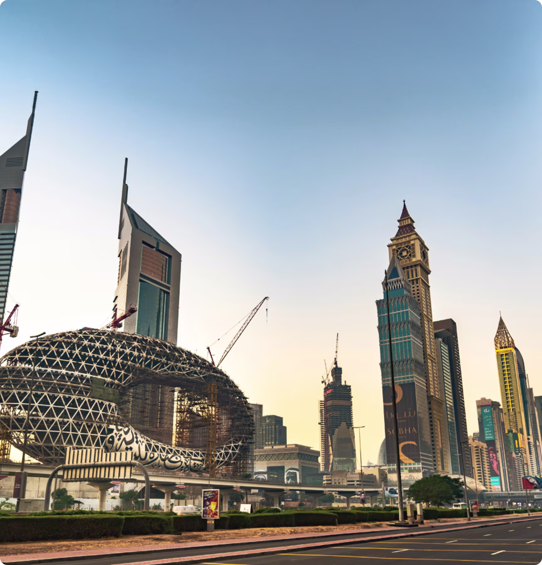 Modern skyscrapers including the Museum of the Future and clock tower buildings along Sheikh Zayed Road in Dubai at sunset.
