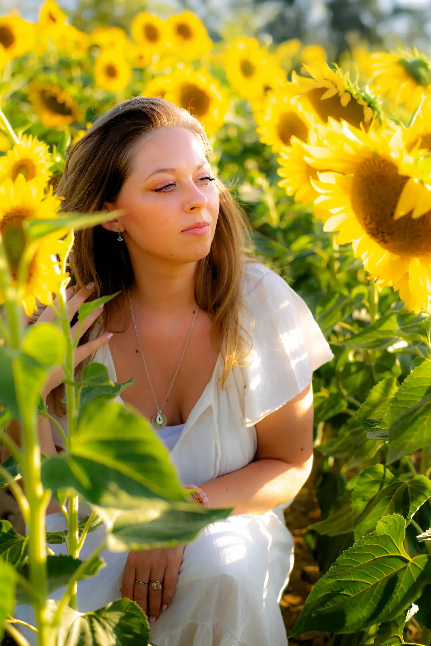 Aline Monneret assise dans un champ de tournesols