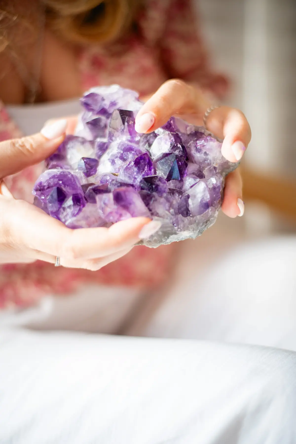 Cristal d’améthyste tenu dans les mains, support d’ancrage et de douceur pendant l’accompagnement thérapeutique d’Aline Monneret.