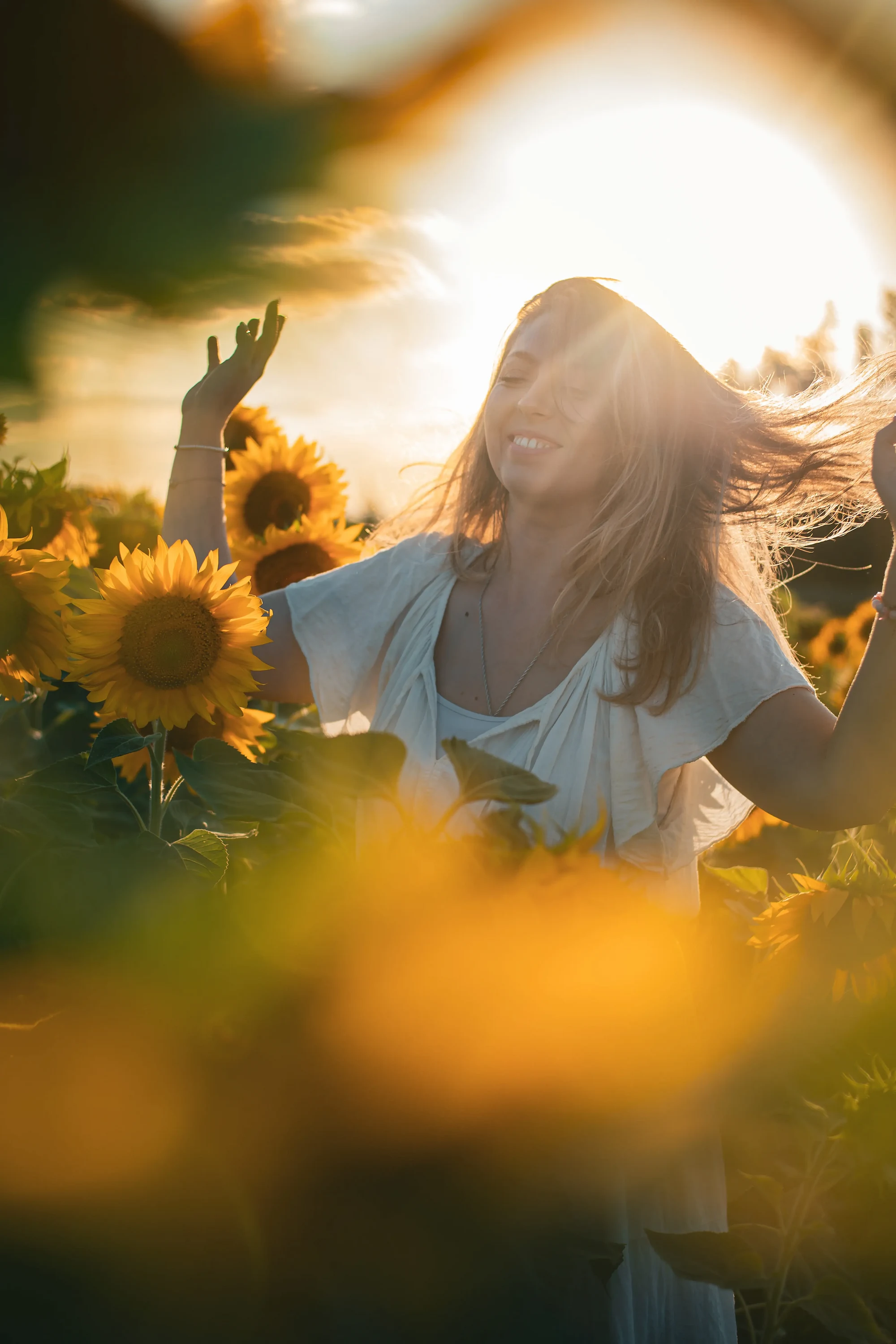 Aline, psychopraticienne, pratique un moment d’ancrage et de respiration consciente dans un champ de tournesols.