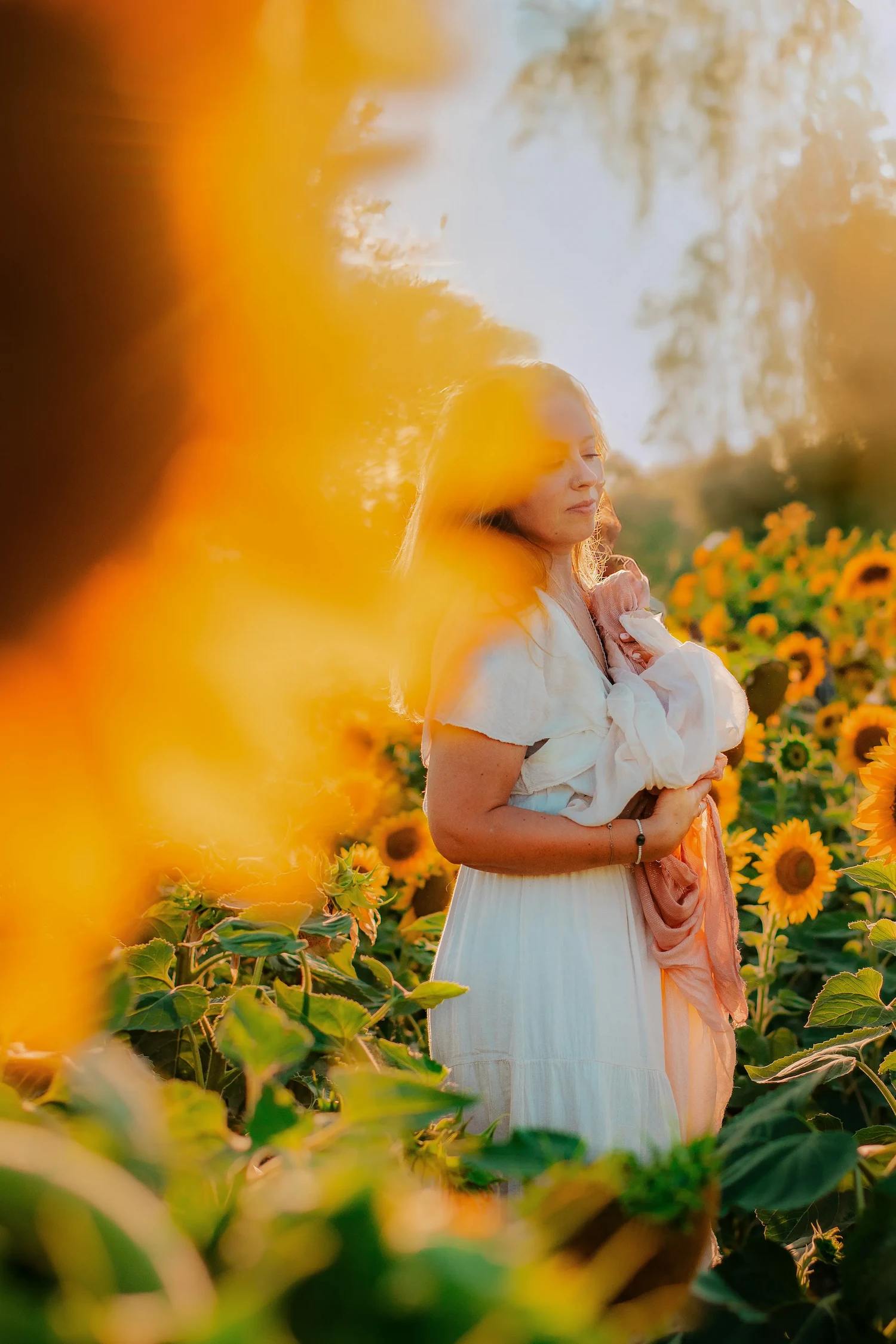 Femme main sur le cœur dans un champ de tournesols , thérapie somatique et maïeusthésie, retour à soi