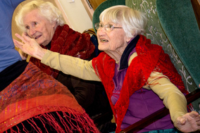 Elderly participants moving and smiling at dementia dance class