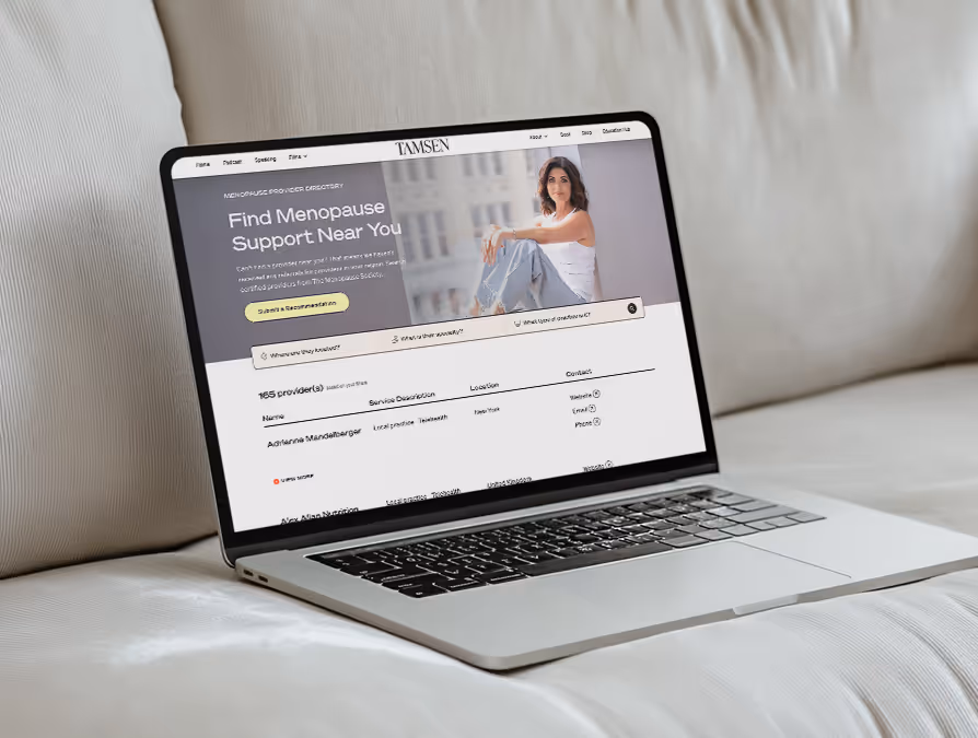 Laptop screen showing a menopause support directory website with a photo of a woman sitting and text inviting users to find menopause support near them.