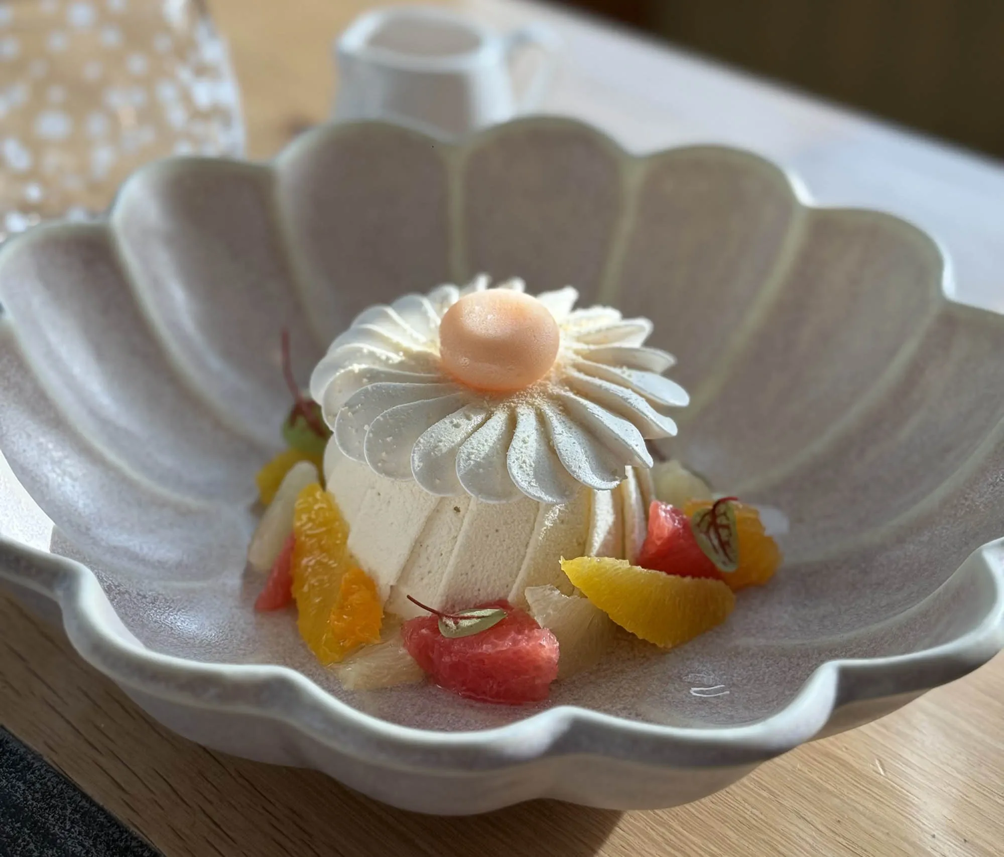 Dessert gastronomique en forme de fleur, accompagné d’agrumes frais, servi au restaurant Cuvée 31 de l’hôtel Armes de Champagne