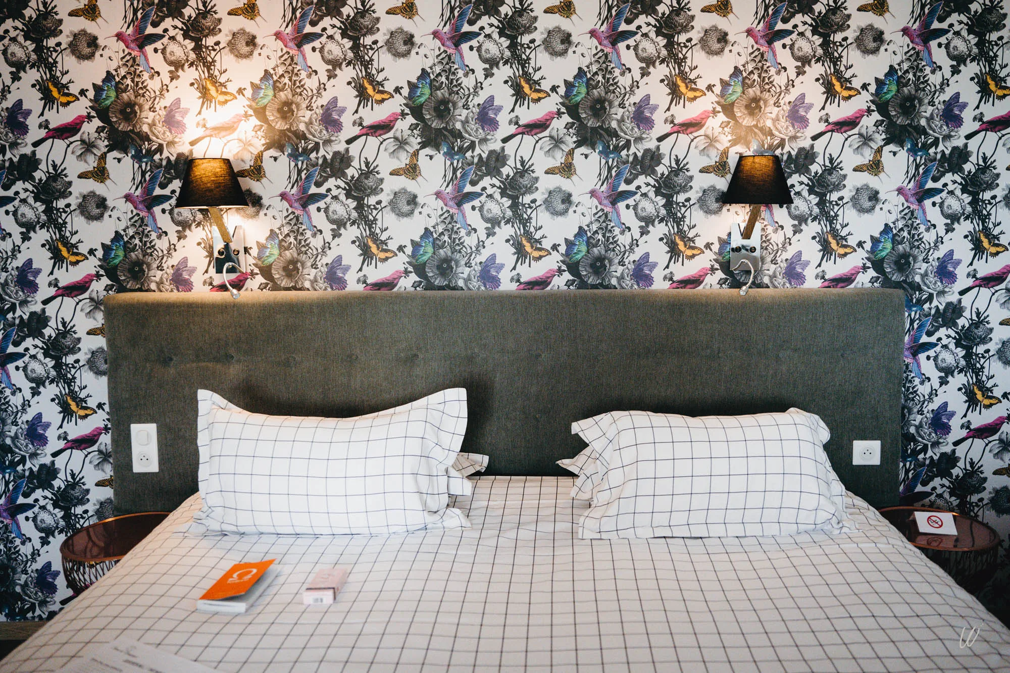Chambre double avec tête de lit rembourrée et papier peint floral coloré aux motifs d’oiseaux et papillons – Hôtel Aux Armes de Champagne