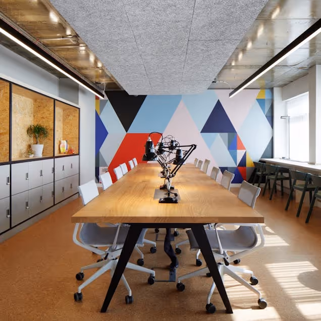 Image of the Alpha Works hot desking area with a geometric mural in the background