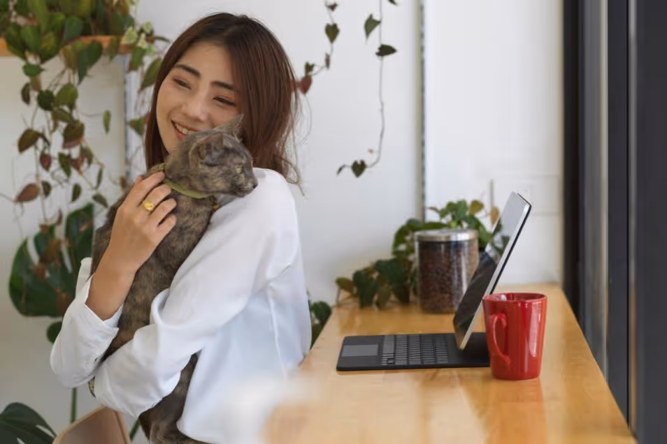 Woman holding her cat at work