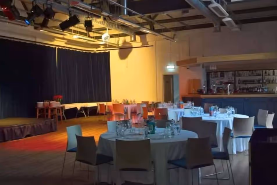 Widcombe Social Club Indoor Event Space with Ceiling Lighting and Tables covered with white sheets