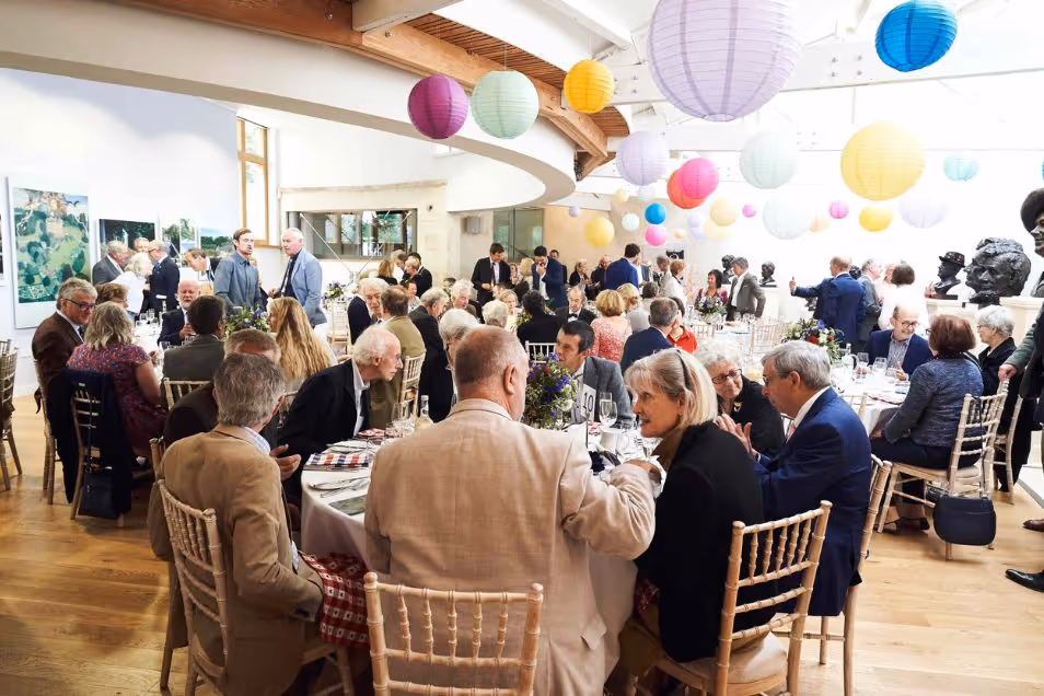 American Museum & Garden Indoor Event Space with colourful lantern lights. Room is filled with people talking