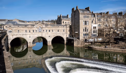 Pulteney Bridge with stone arches reflecting in River Avon in Bath, England