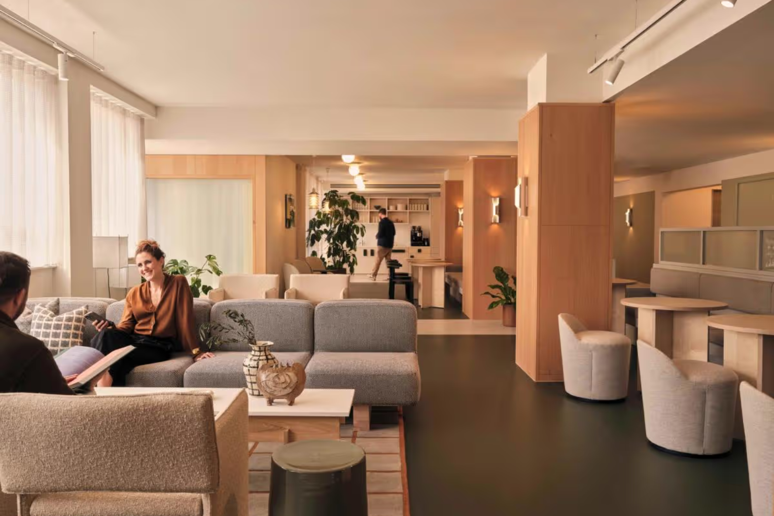 Fora - Henry Wood House Coworking Space with two people sat talking on grey cushioned sofas