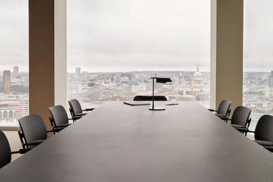 Boardroom with a long grey table and black chairs, featuring a panoramic window view of the London skyline and St. Paul's Cathedral.