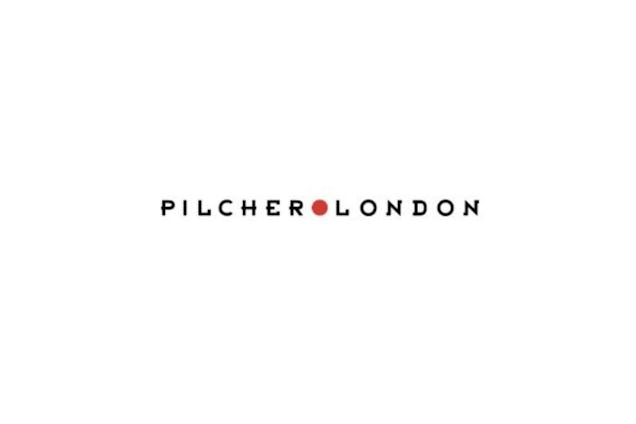 Pilcher London logo, showing the brand name in spaced black capital letters with a small red dot separating the two words.
