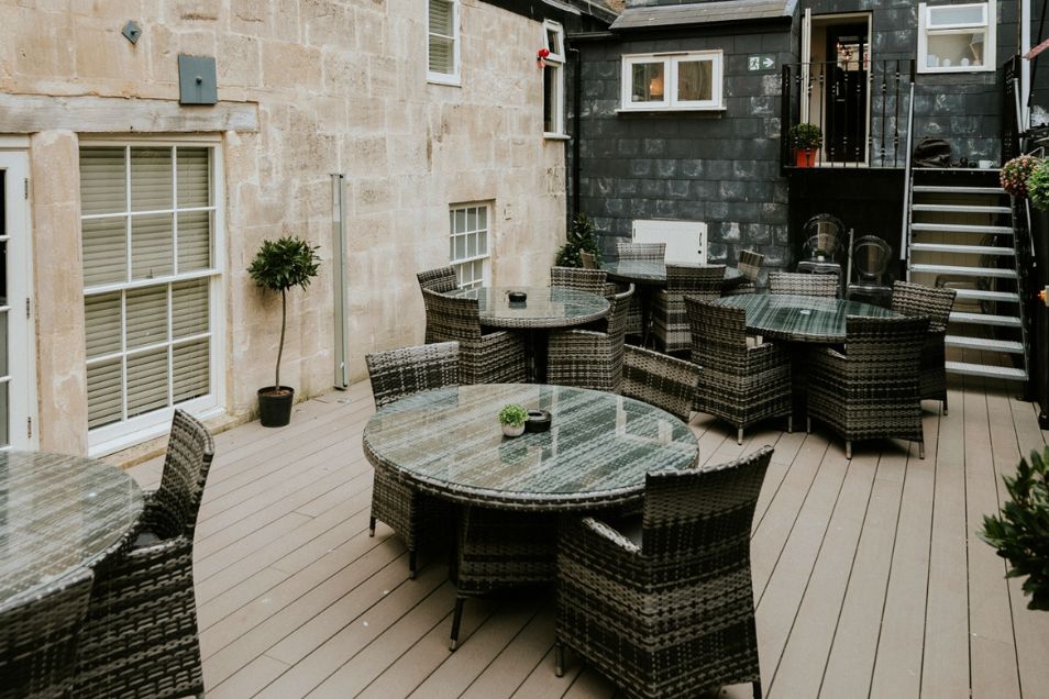 Rengen House Outdoor Event Space with glass tables and grey chairs
