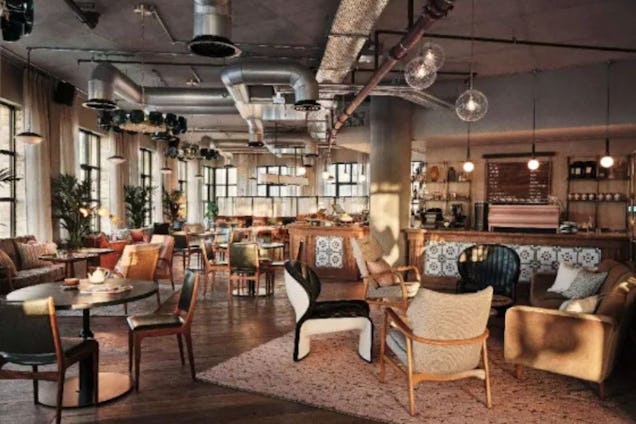 Multi-coloured armchairs and tables are arranged in a lounge with a rug and a bar in the background.