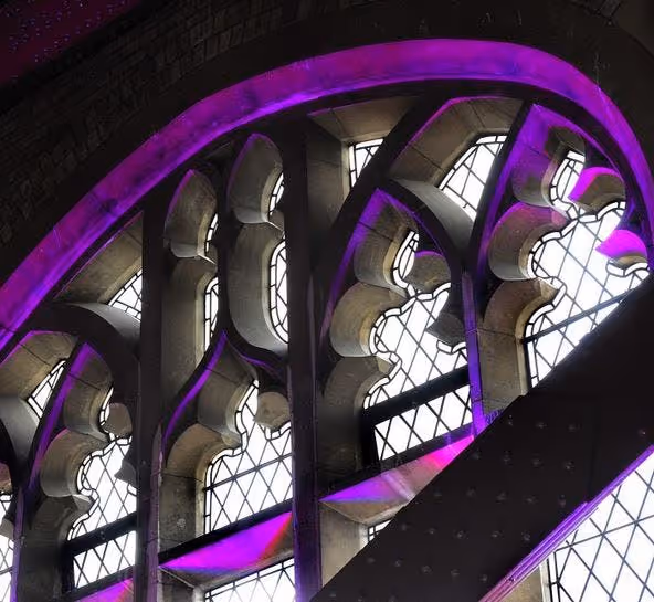 Arched interior windows with decorative detailing, lit by purple accent lighting, highlighting the architectural features.