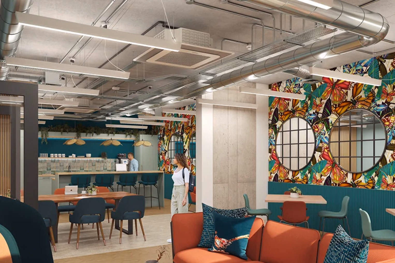 An orange sofa with patterned teal pillows, wooden tables, a kitchen counter bar in the background, and a distinctive butterfly-patterned accent wall.