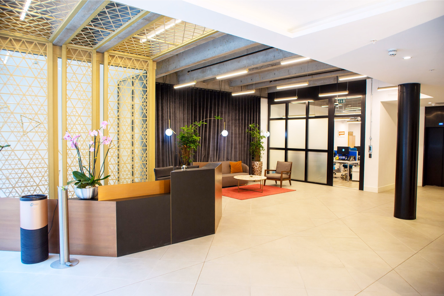 A reception area with a wooden reception desk and pink orchids.
