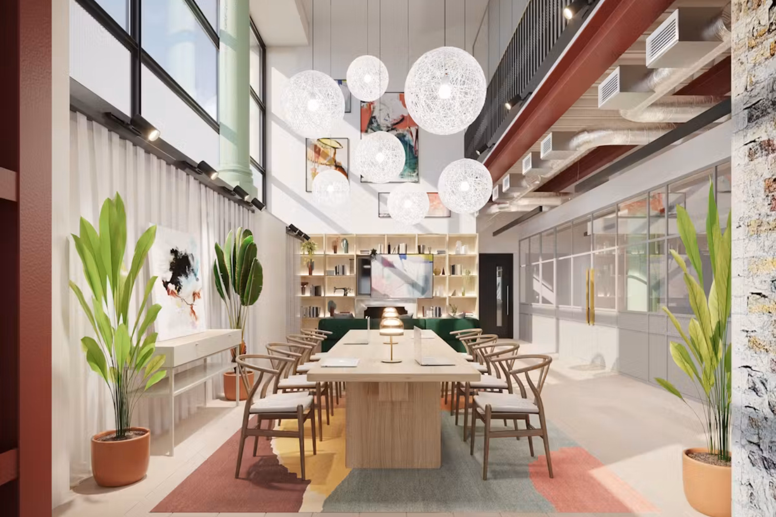 Wooden dining chairs surround a light-wood desk set over a colourful abstract rug in an office atrium, highlighted by a cluster of spherical pendant lights.