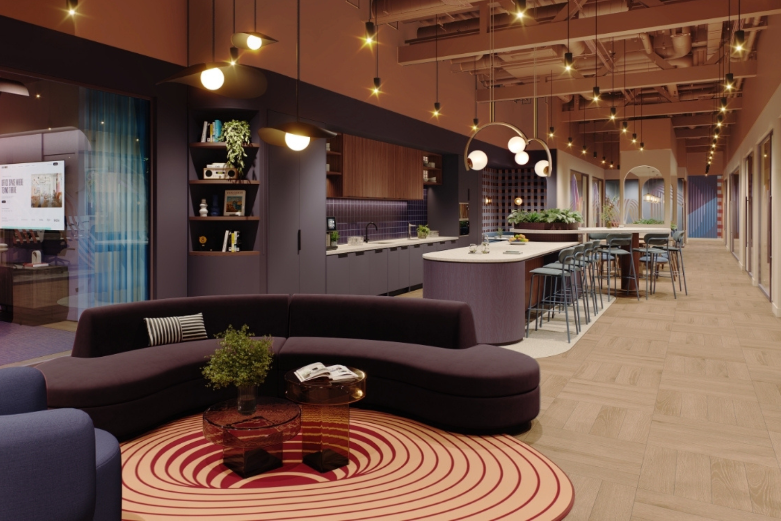 A purple sofa on a circular rug around glass tables in an office lounge,  nearby a kitchen island with barstools, warm ceiling lighting, and light wood flooring.