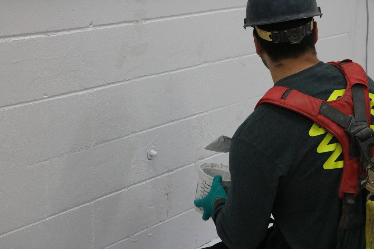 Repairing and patching a concrete block wall before applying heavy-duty food-grade coatings in Woodstock.