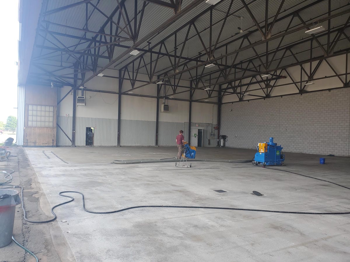 Applying high-performance aviation-grade epoxy flooring to a private airport hangar in Brantford.