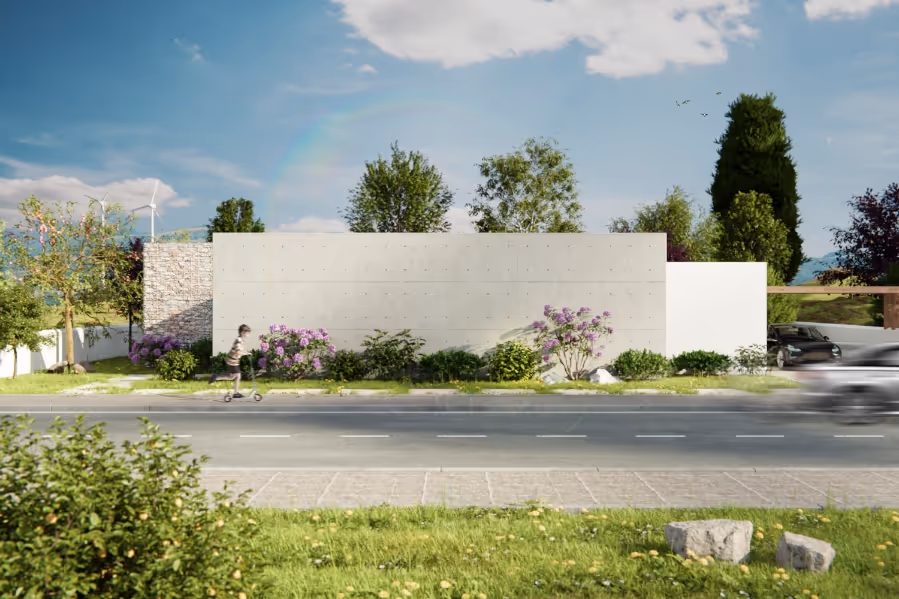 Modern house with a tall concrete wall, landscaped garden, and a child riding a scooter on the road in front.