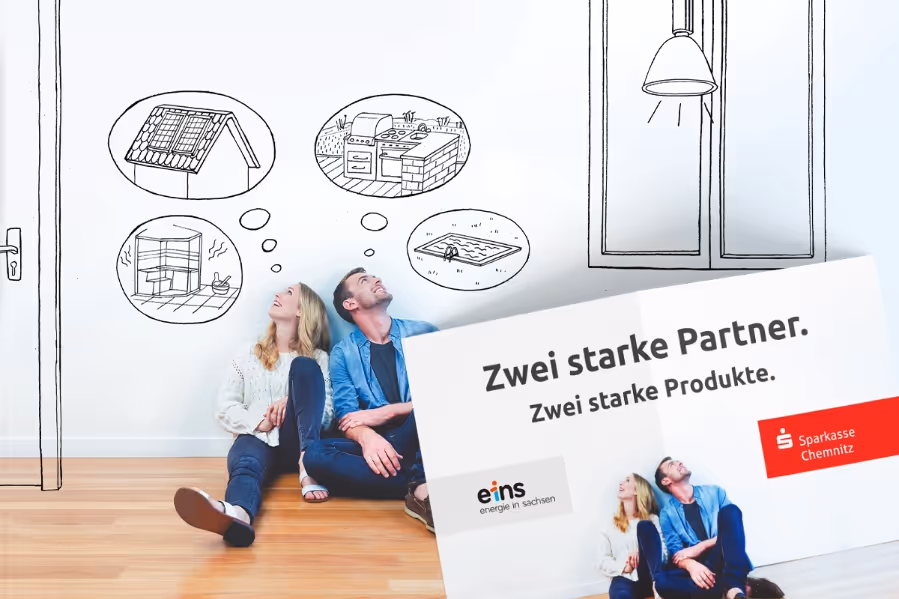 Couple sitting on wooden floor leaning against a white wall with drawn thought bubbles showing a solar panel on a roof, an outdoor kitchen, a pool, and a fireplace, alongside text in German about strong partnership between eins energie in sachsen and Sparkasse Chemnitz.
